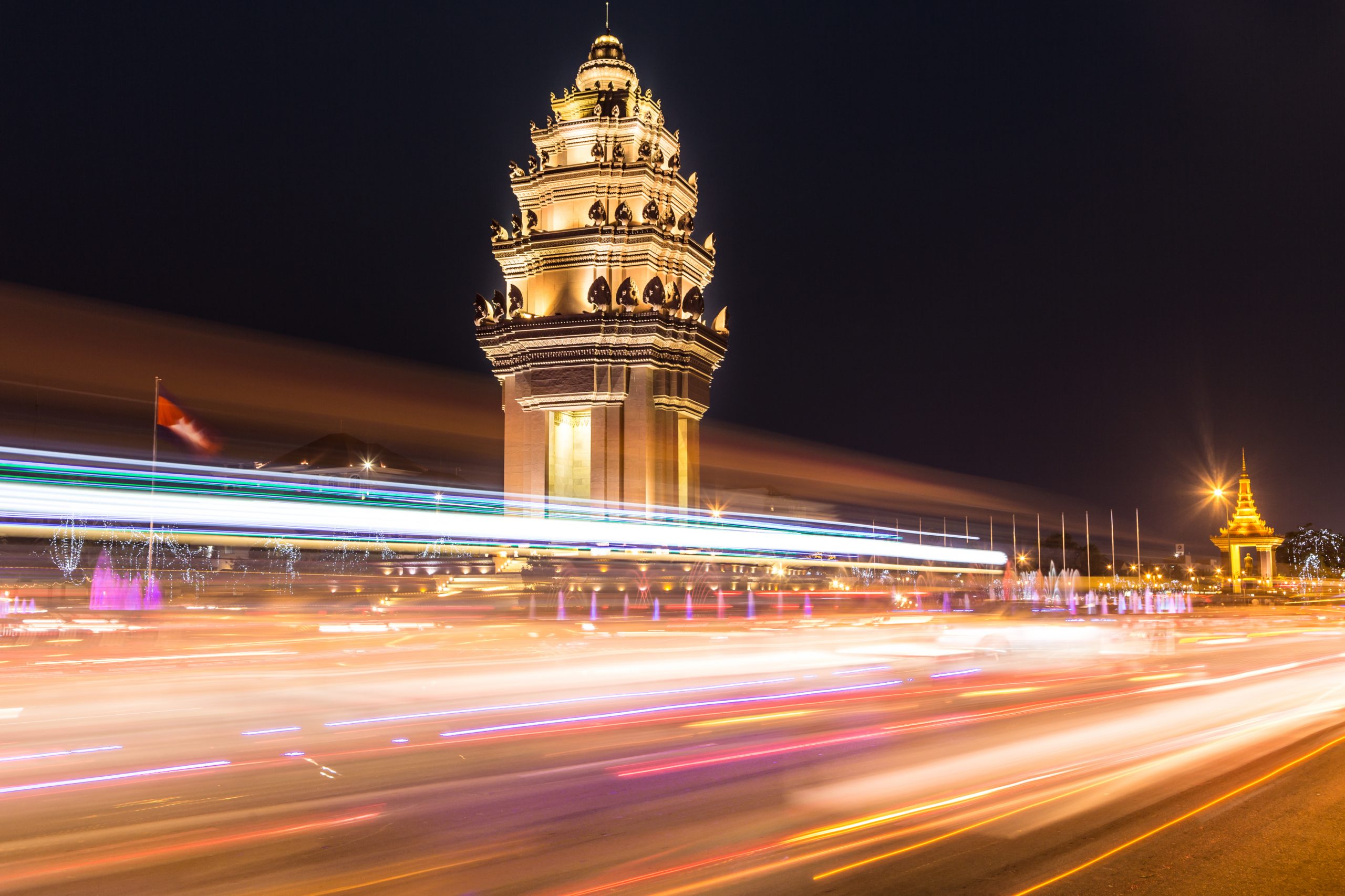 Phnom Penh temple at night with vehicle lights passing by