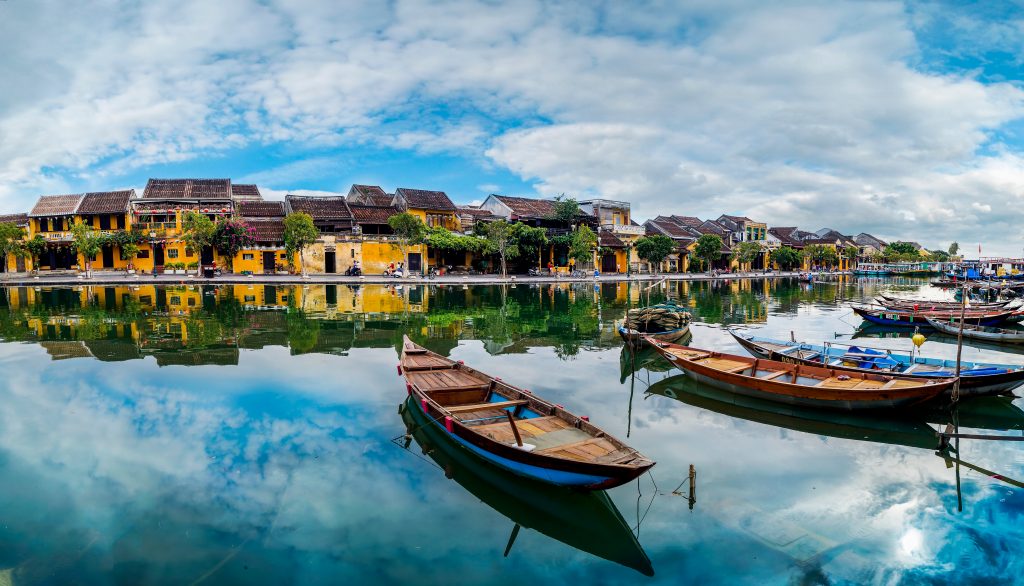 River scene of boats with historic Hoi An Houses behind