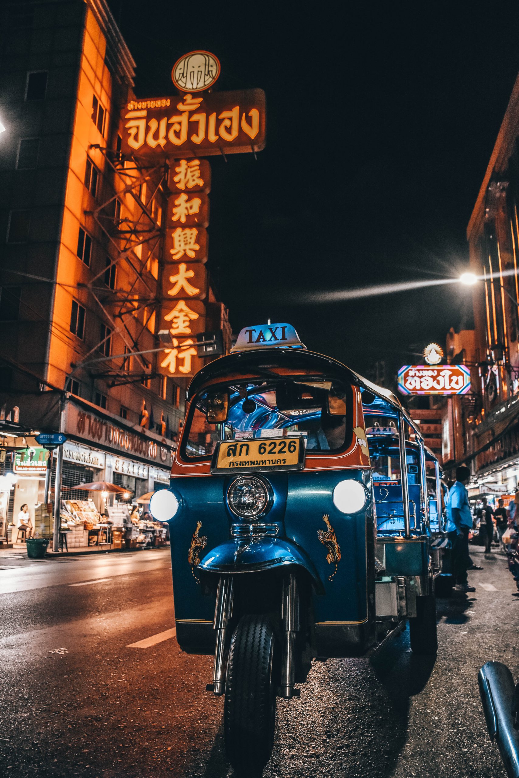 Tuk Tuk at night driving through Chinatown, Bangkok