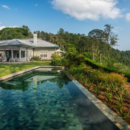 View of infinity pool, garden and Nine Skies tea planter bungalow near Ella