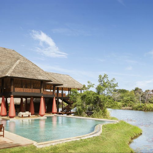 View of pool and restaurant overlooking a lake. Jetwing Vil Uyana. Cultural Triangle