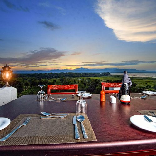 View of dining table at sunset and view of countryside and uda walawe reservoir in distance